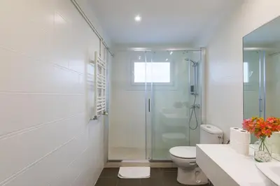 a white bathroom with a shower and a toilet at Penthouse City Center With 2 Terraces And Views in Barcelona