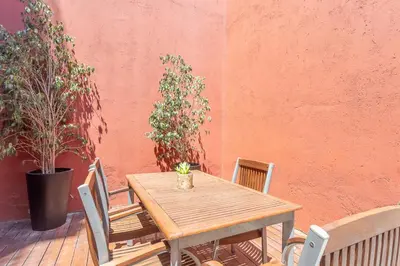a wooden table and chairs on a patio at My Space Barcelona Pool City Center in Barcelona