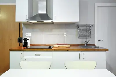 a kitchen with white cabinets and a sink at Barcelona Mercaders Apartments in Barcelona