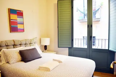 a bedroom with a bed with green shuttered windows at Barcelona Mercaders Apartments in Barcelona