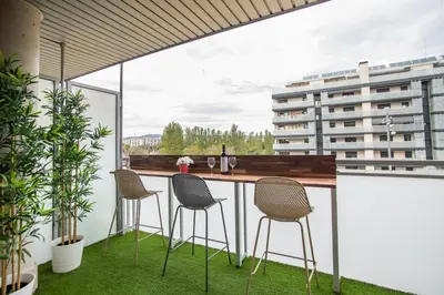 a balcony with a table and chairs and a building at Tendency Apartments Forum in Sant Adria de Besos