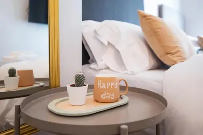 a coffee table with a happy day mug and cactus at Tendency Apartments Forum in Sant Adria de Besos
