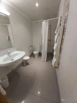 a white bathroom with a sink and a toilet at Gatell Hotel in Vilanova i la Geltrú
