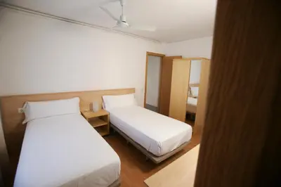 a hotel room with two beds and a mirror at Gatell Hotel in Vilanova i la Geltrú