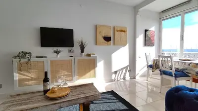 a living room with a table and a tv on a wall at CATALINA PORT & BEACH -3 dormitorios in Masnou