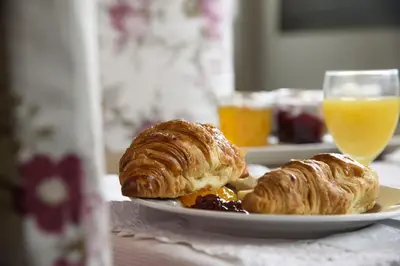 two pastries on a plate with a glass of orange juice at Anita's Bed and Breakfast in Barcelona