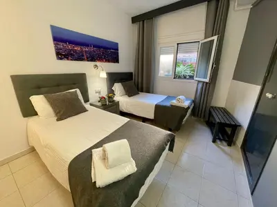 a hotel room with two beds and a window at Hostal Lleida in Barcelona