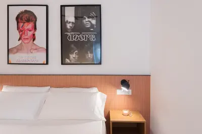 a bedroom with a bed and three pictures on the wall at Petit Luxe l'Àtic in Terrassa