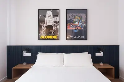 a bedroom with three framed posters above a bed at Petit Luxe l'Àtic in Terrassa