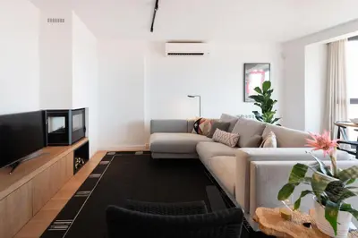 a living room with a couch and a tv at Petit Luxe l'Àtic in Terrassa
