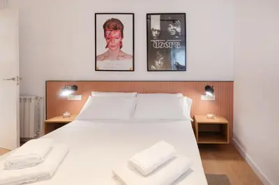 a bedroom with a bed with three pictures on the wall at Petit Luxe l'Àtic in Terrassa