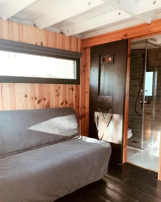a bedroom with a bed and a glass shower at HolaCamp Sitges Garrofer in Sitges