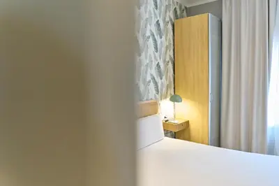 a bedroom with a white bed and a window at Fira Apartments by gaiarooms in Barcelona