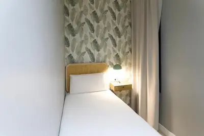 a small bedroom with a bed and a side table at Fira Apartments by gaiarooms in Barcelona