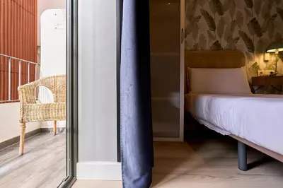 a bedroom with a bed and a glass wall at Fira Apartments by gaiarooms in Barcelona