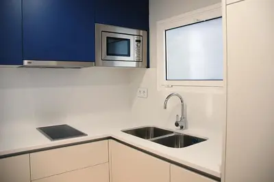 a kitchen with a sink and a microwave at Apartamentos Sunway Arizona in Sitges