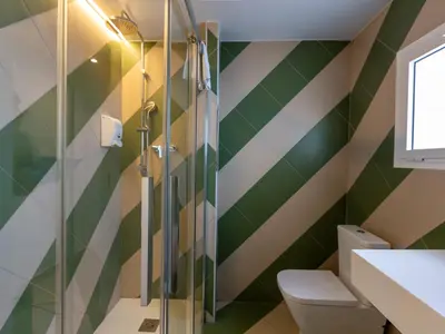 a bathroom with green and white stripes at Apartamentos Sunway Arizona in Sitges