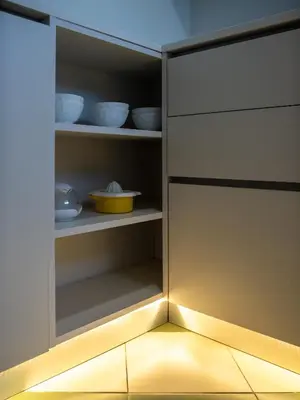 an open kitchen cabinet with a light inside at Apartamentos Sunway Arizona in Sitges