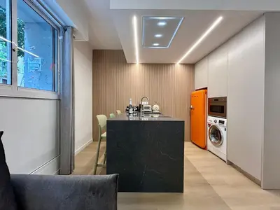 a kitchen with a black counter and a washing machine at BarcelonaForRent Sant Pau Suite in Barcelona