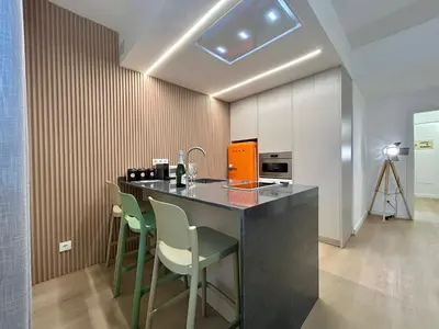a kitchen with a bar with chairs and a microwave at BarcelonaForRent Sant Pau Suite in Barcelona