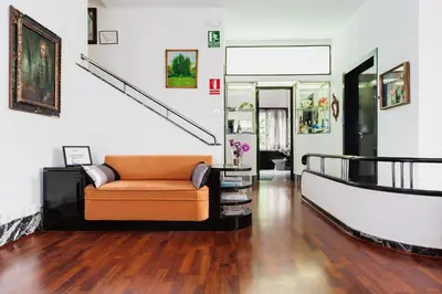 a living room with a couch and a staircase at Casa Vilaró Park Guell in Barcelona