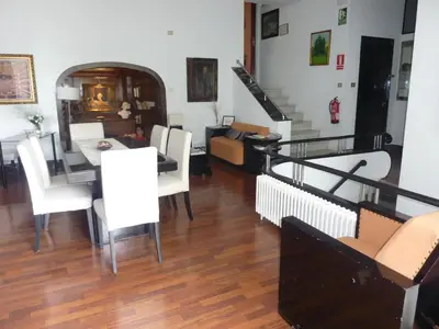 a dining room and living room with a table and chairs at Casa Vilaró Park Guell in Barcelona