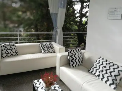 two white couches and a table on a porch at Casa Vilaró Park Guell in Barcelona