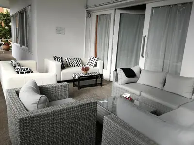 a living room with wicker couches and a table at Casa Vilaró Park Guell in Barcelona