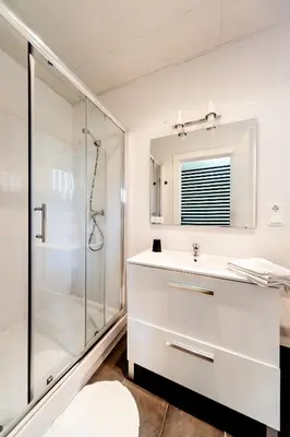 a white bathroom with a shower and a sink at Casa Vilaró Park Guell in Barcelona