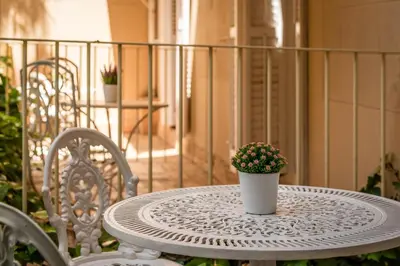 a white table with a potted plant on a balcony at Hotel Medium Renaixença in Sitges