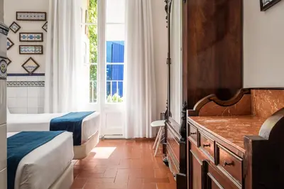a bedroom with two beds and a window at Hotel Medium Renaixença in Sitges