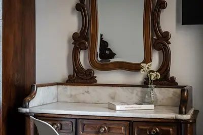 a mirror and a table with a book on it at Hotel Medium Renaixença in Sitges