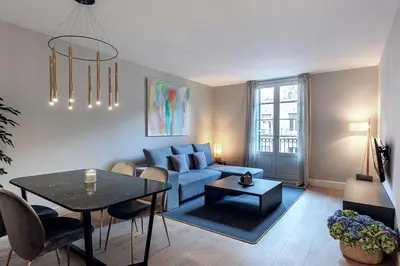 a living room with a blue couch and a table at Weflating City Center in Barcelona