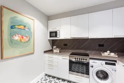 a kitchen with a stove top oven next to a washing machine at Weflating City Center in Barcelona
