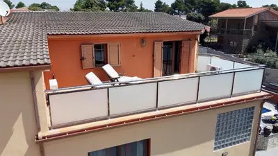 a balcony with two chairs on top of a building at Raco de Lis in La Torre de Claramunt