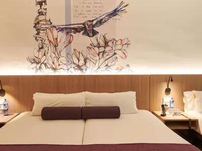 a hotel room with a bed and a desk and a window at Mercure Barcelona Condor in Barcelona