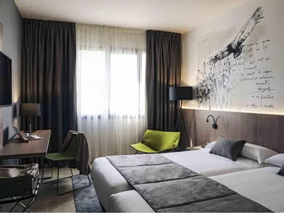 a desk with a chair next to a table with a lamp at Mercure Barcelona Condor in Barcelona