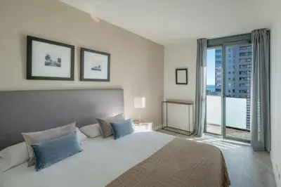 a bedroom with a large bed and a large window at Rent Top Apartments Beach-Diagonal Mar in Barcelona