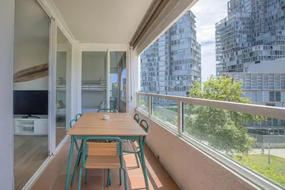 a balcony with a wooden table and chairs on it at Rent Top Apartments Beach-Diagonal Mar in Barcelona