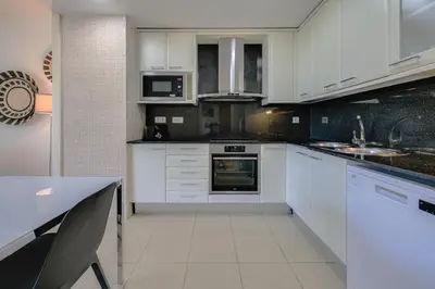 a kitchen with white cabinets and a counter top at Rent Top Apartments Beach-Diagonal Mar in Barcelona
