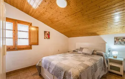 a bedroom with a bed and a wooden ceiling at 4 Bedroom Nice Home In Riells I Viabrea in Breda
