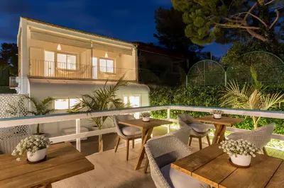 a patio with tables and chairs and a building at Antonio's House in Sitges