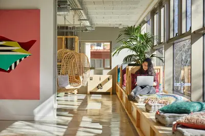 a woman sitting on a table in a room with a laptop at Unite Hostel Barcelona in Barcelona