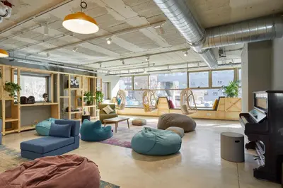 a living room with blue furniture and a room with windows at Unite Hostel Barcelona in Barcelona