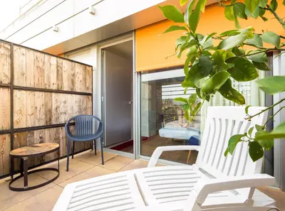 a balcony with a white chair and a bed at Generator Barcelona in Barcelona