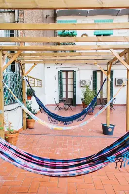 a hammock on a patio in a building at ZOOROOMS Boutique Guesthouse in Barcelona