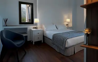 a bedroom with a bed and a chair and a mirror at La Frasera Alojamiento Rural in Vacarisas