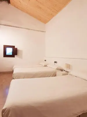 a room with three beds and a tv on the wall at La Frasera Alojamiento Rural in Vacarisas