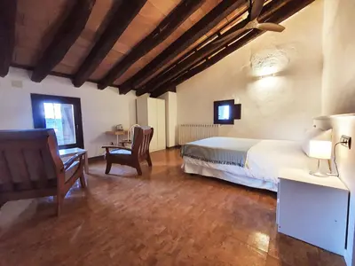 a bedroom with a bed and a desk and a chair at La Frasera Alojamiento Rural in Vacarisas