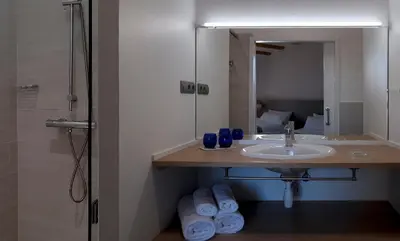 a bathroom with a sink and a mirror at La Frasera Alojamiento Rural in Vacarisas